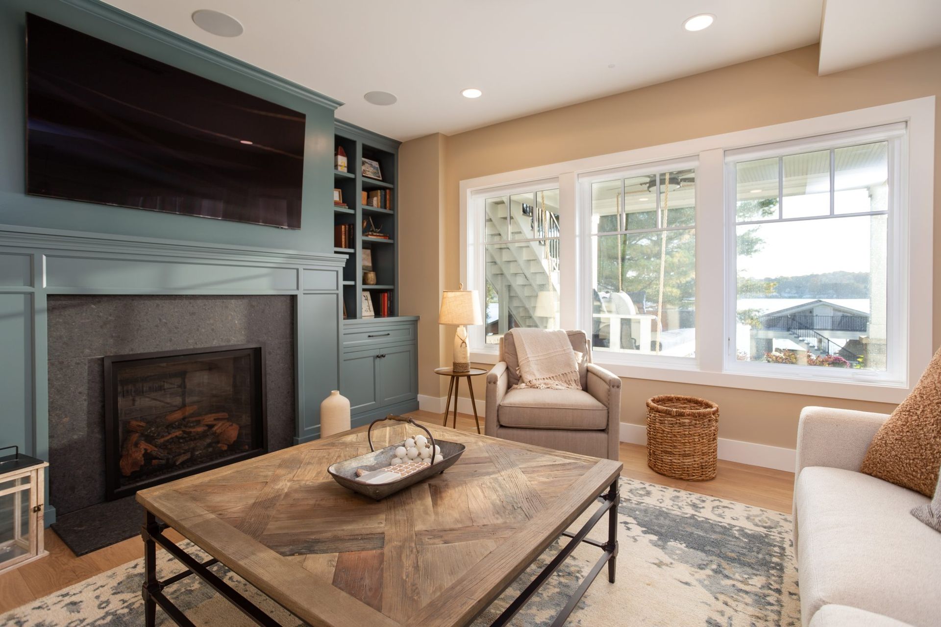 A living room with a fireplace, couch, chair, coffee table and television.