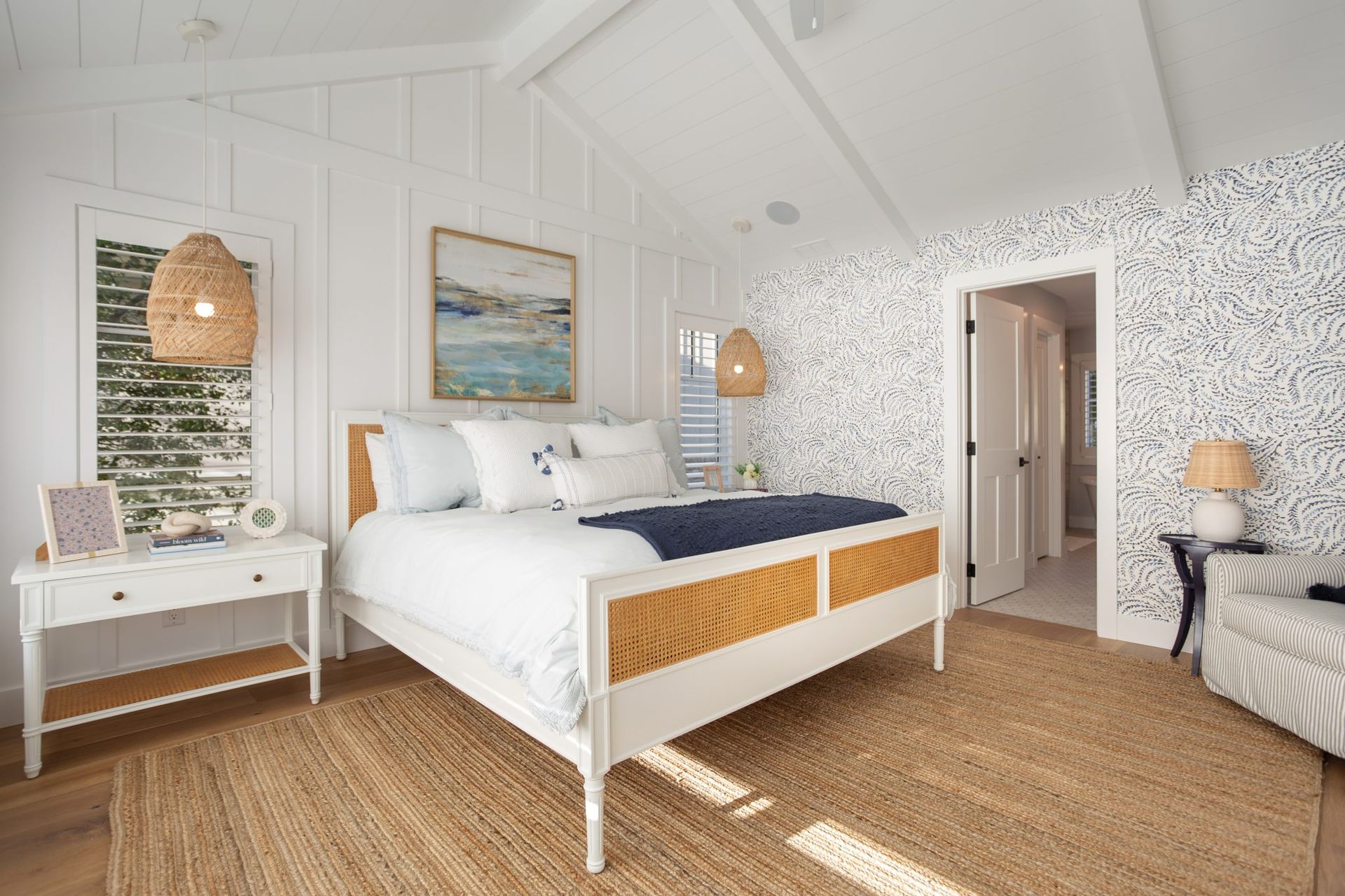 A bedroom with a bed, nightstand, chair and rug.