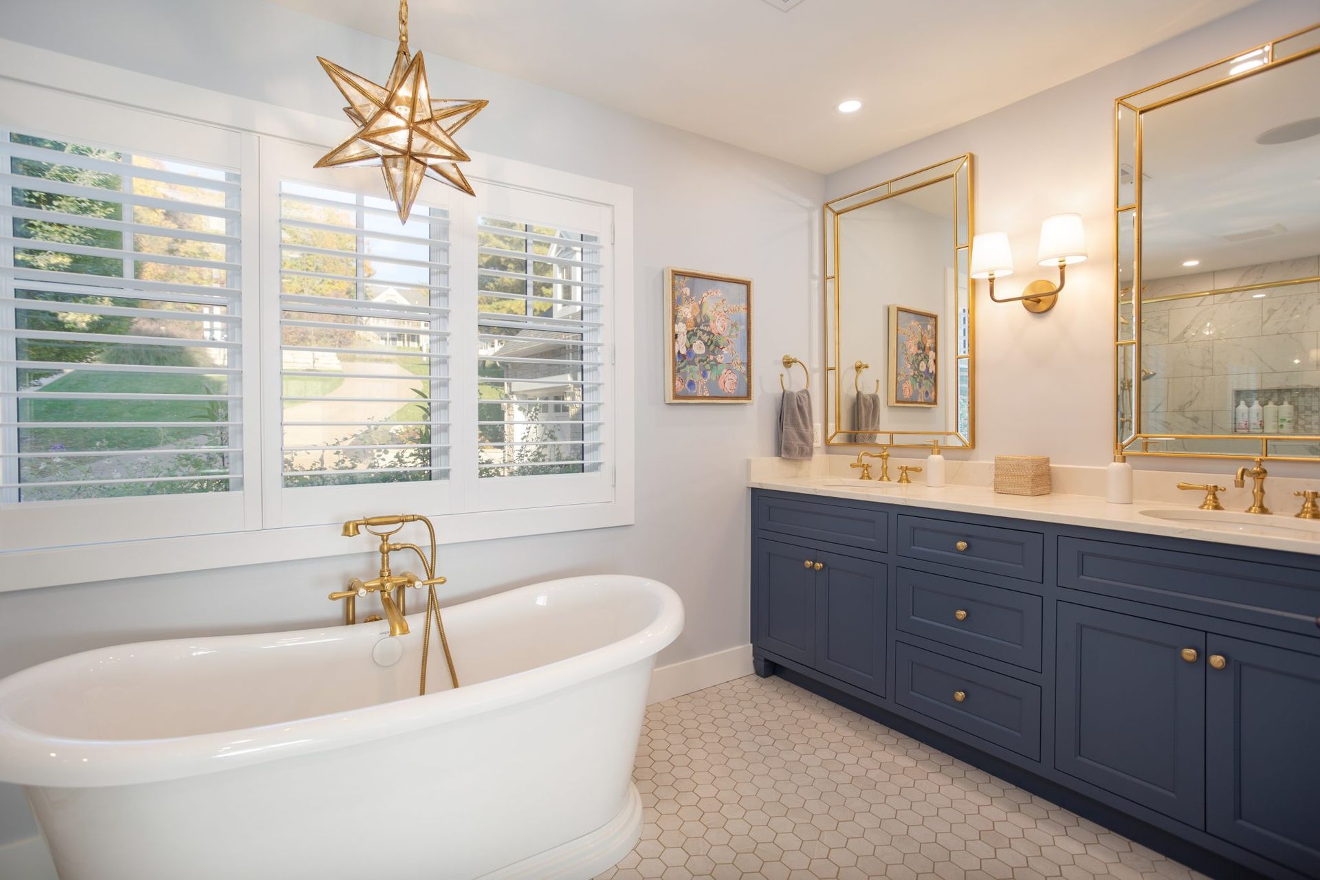 A bathroom with a bathtub , sink , mirror and shutters.