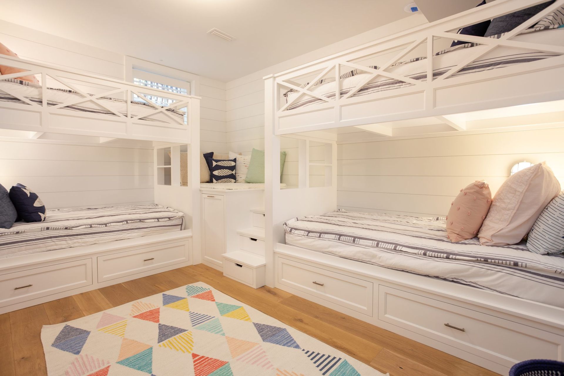 A bedroom with three bunk beds and a rug.