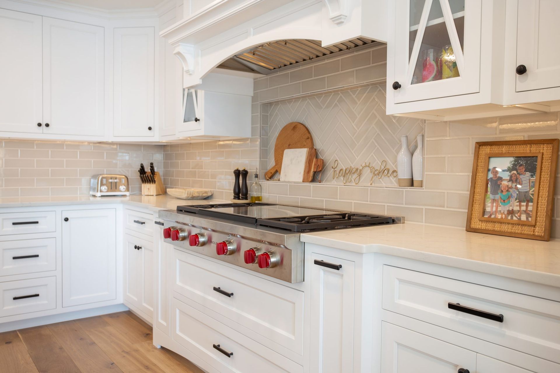 A kitchen with white cabinets and a stove top oven.