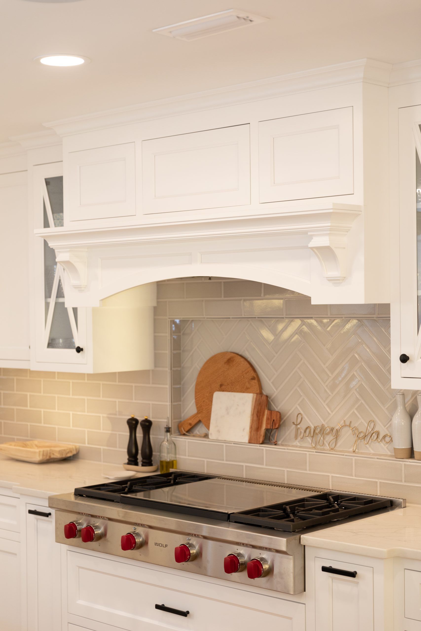 A kitchen with white cabinets and a stove top oven.