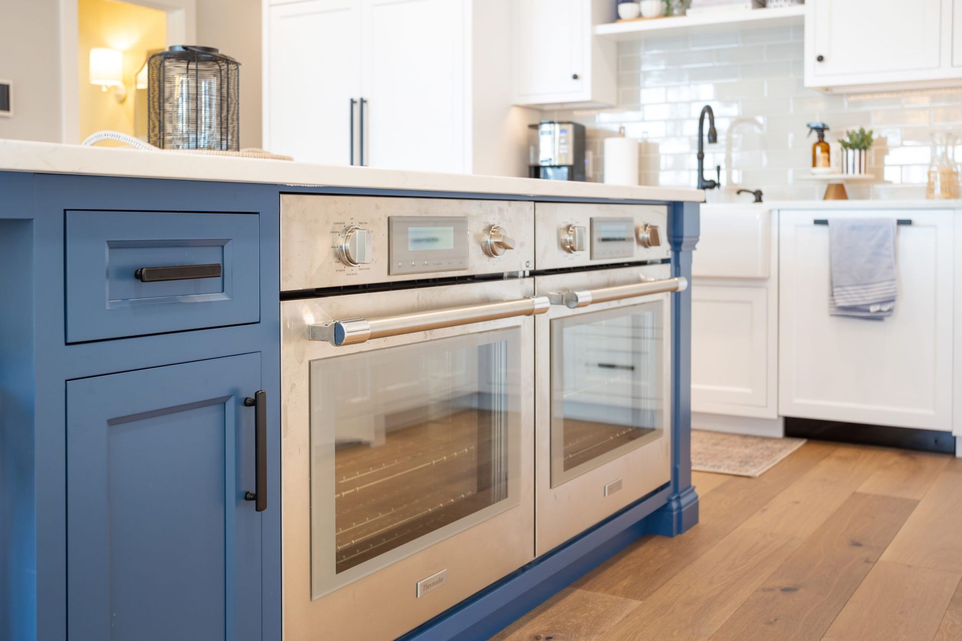 A kitchen with blue cabinets and stainless steel appliances.