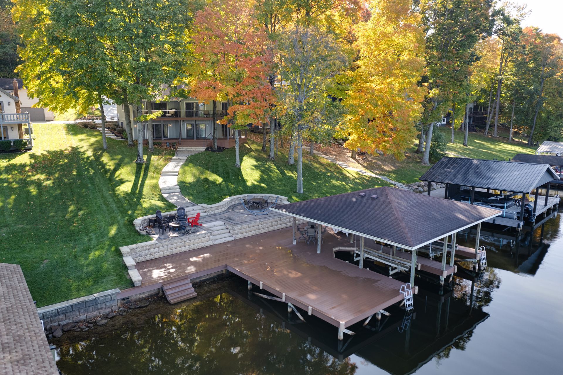 An aerial view of a dock and a house on a lake.