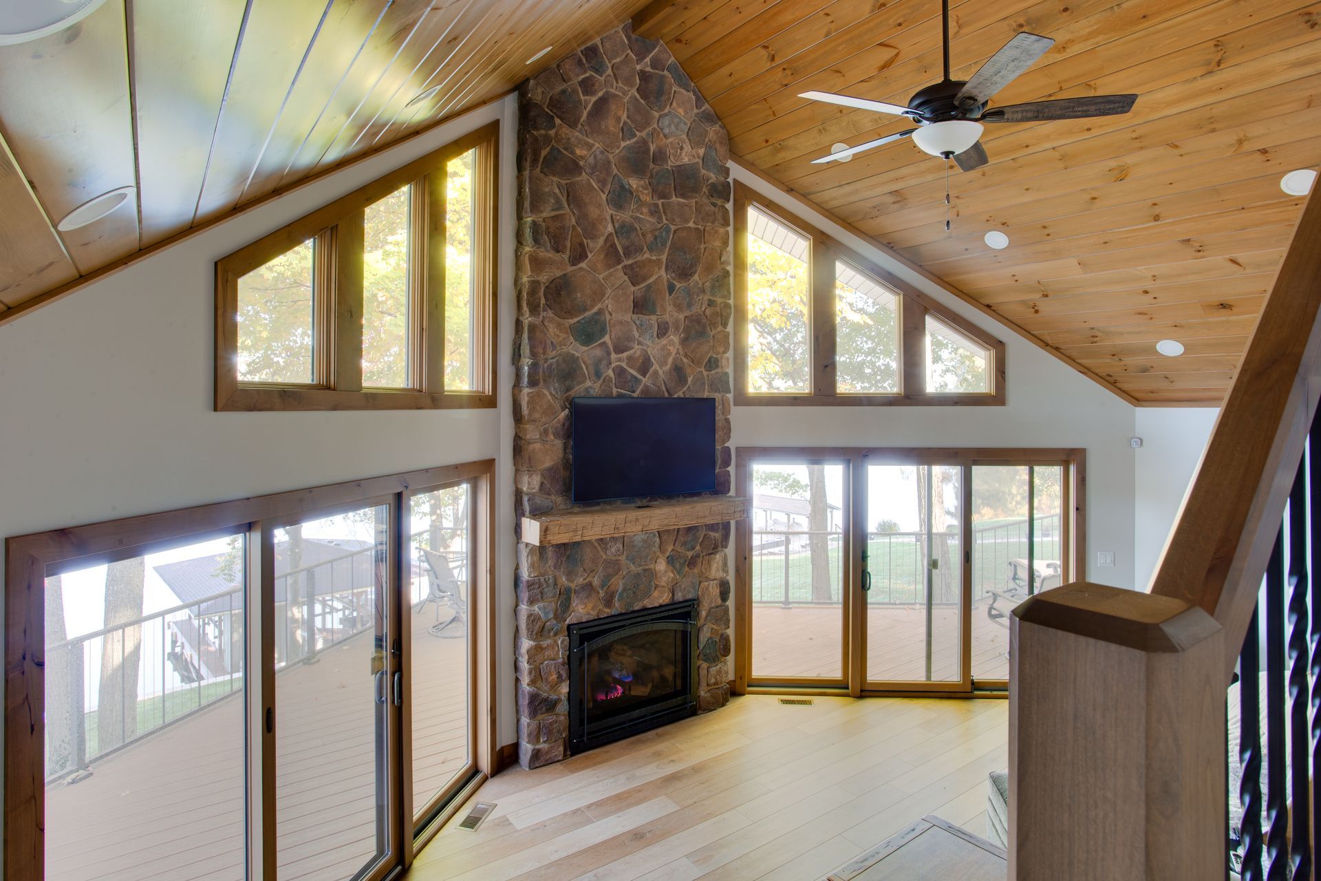 A living room with a fireplace , television and ceiling fan.