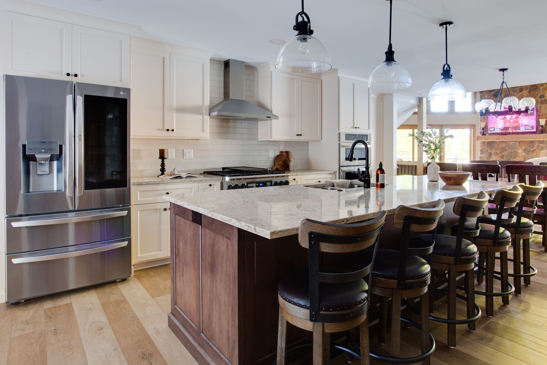 A kitchen with a large island and a stainless steel refrigerator.