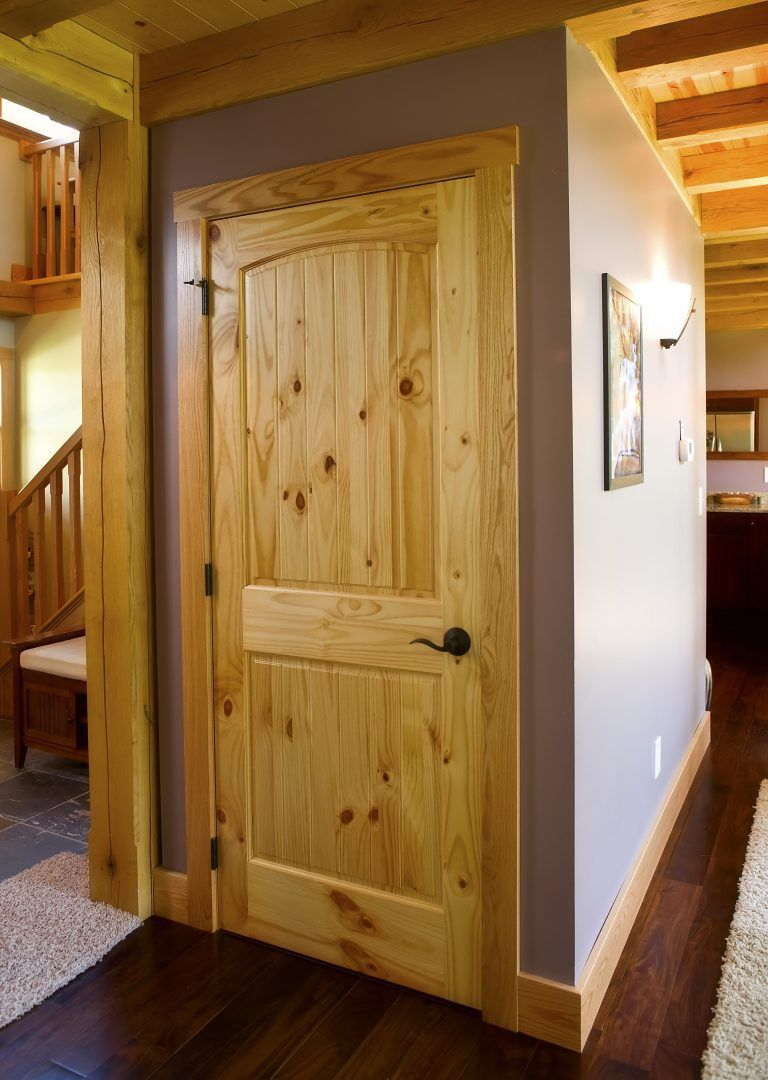 A wooden door in a hallway next to a staircase.