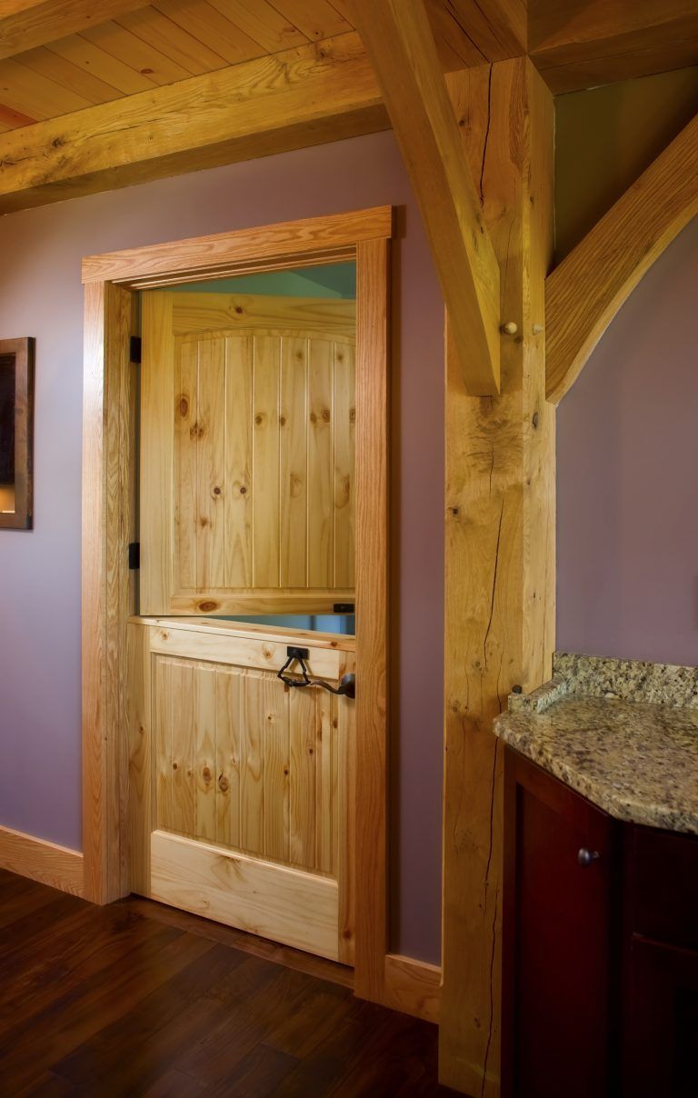 A wooden door in a room with purple walls and a granite counter top.