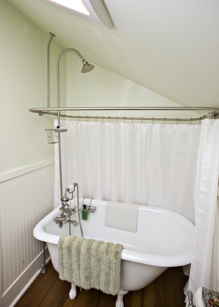 A bathtub in a bathroom with a white shower curtain.