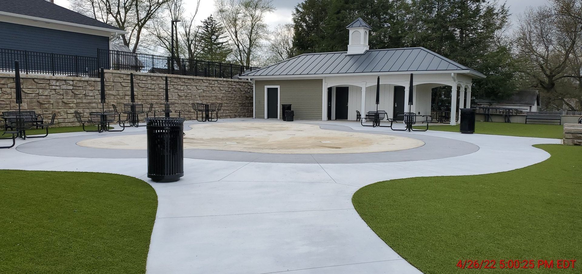 A concrete walkway leading to a building in a park