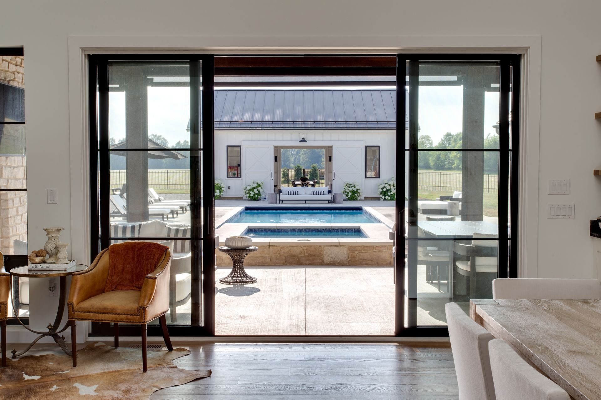 A living room with sliding glass doors leading to a pool.