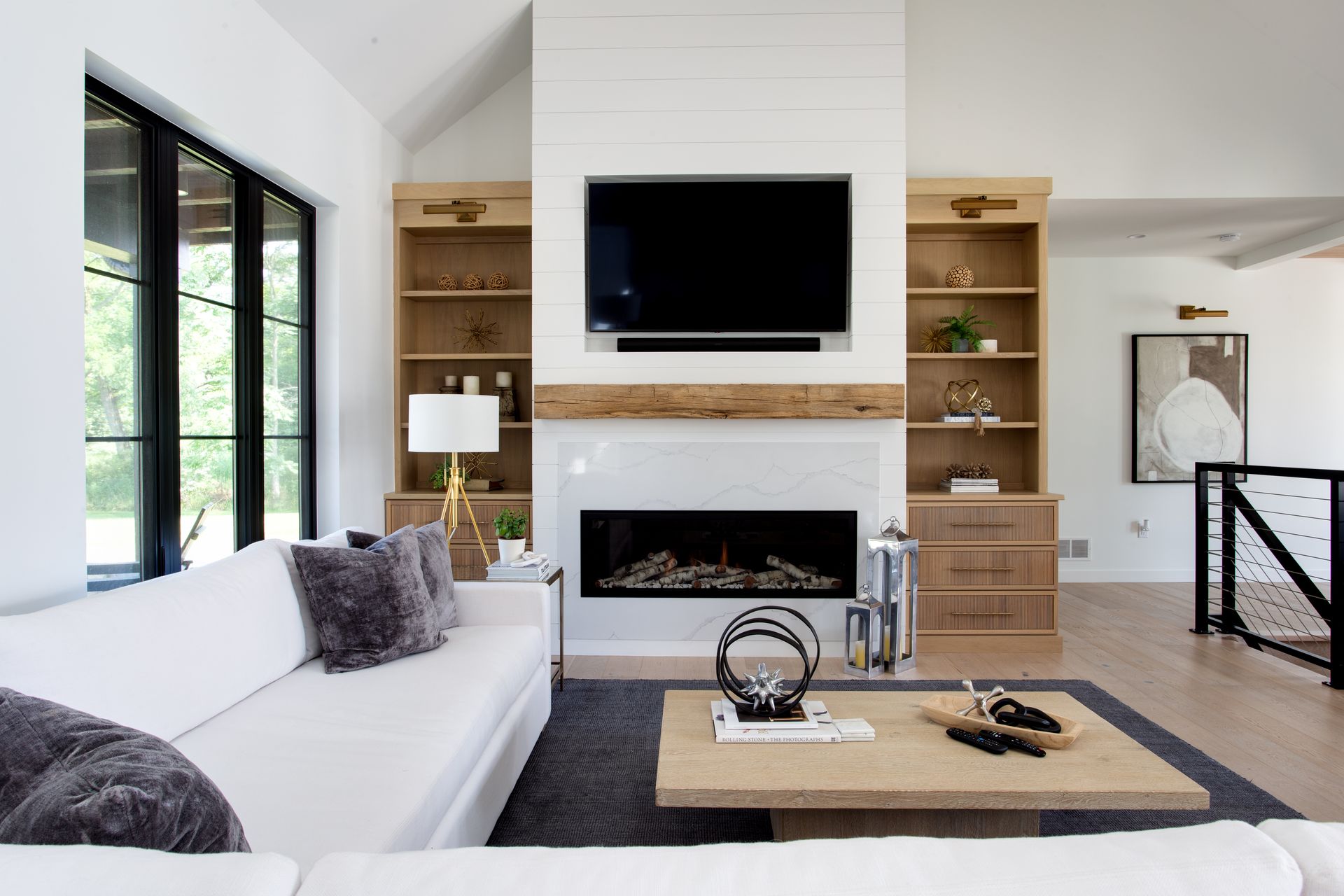 A living room with a fireplace , couch , coffee table and television.