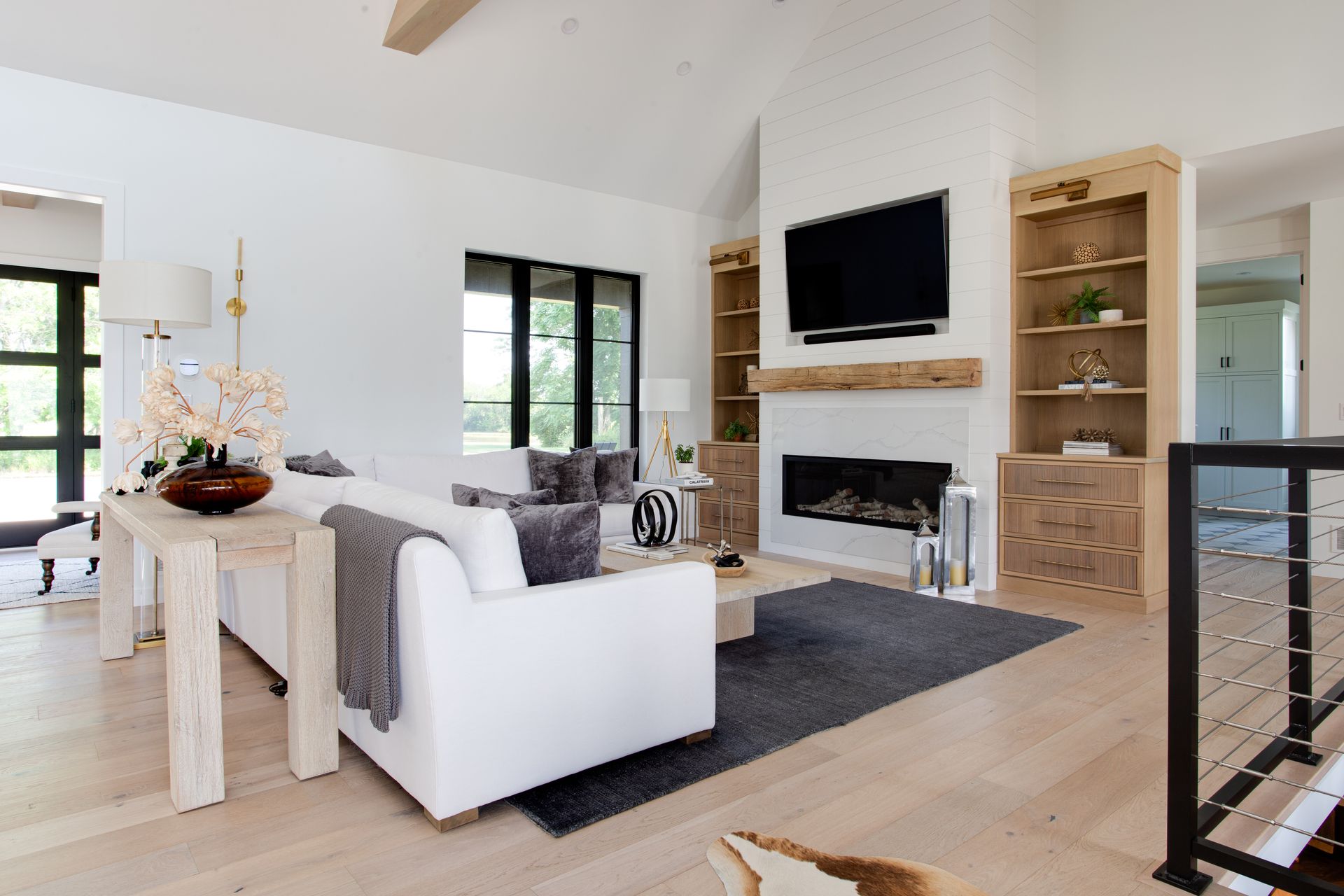 A living room with a couch, chair, fireplace and television.