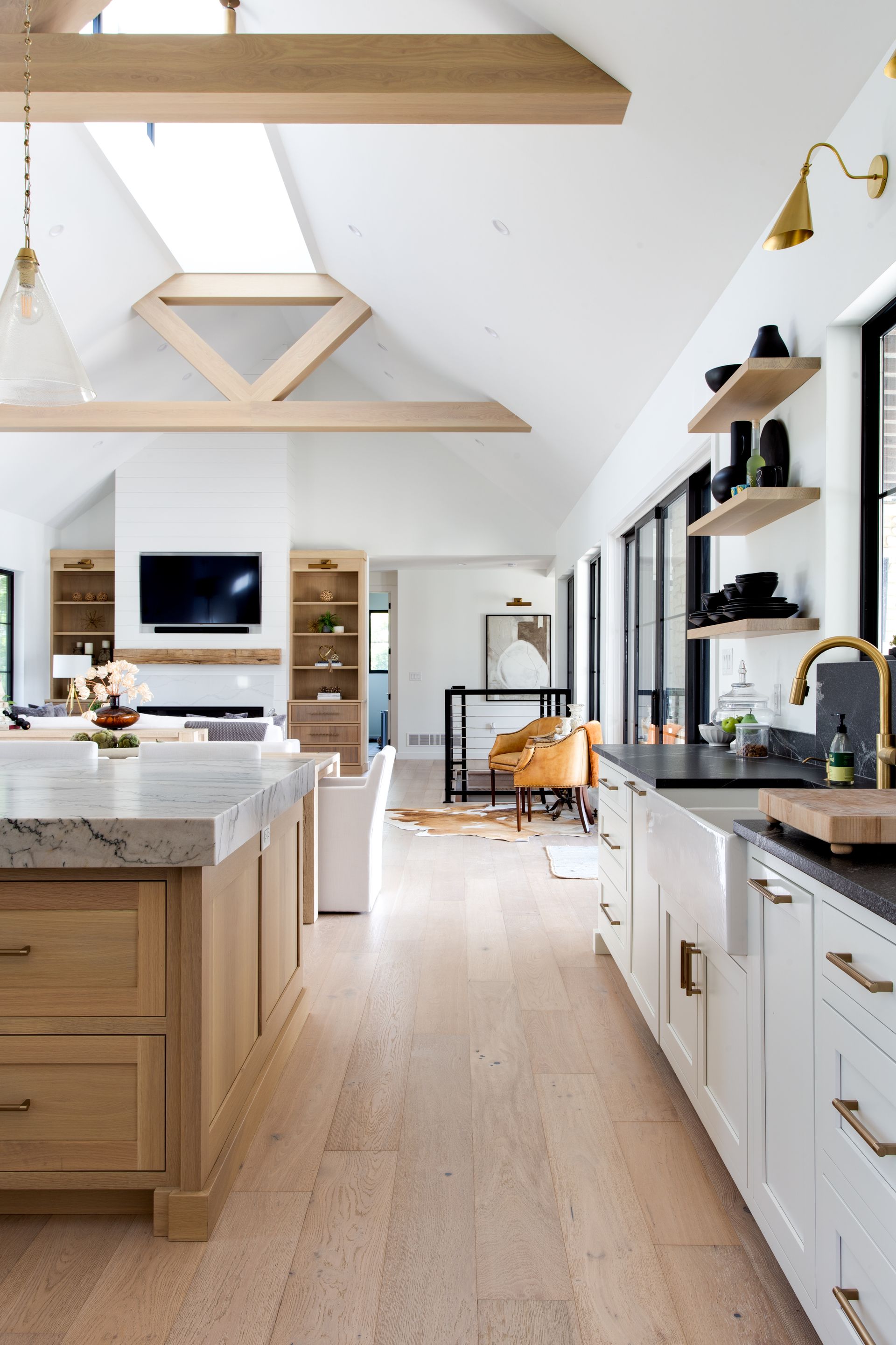 A kitchen with white cabinets, marble counter tops, and a large island.