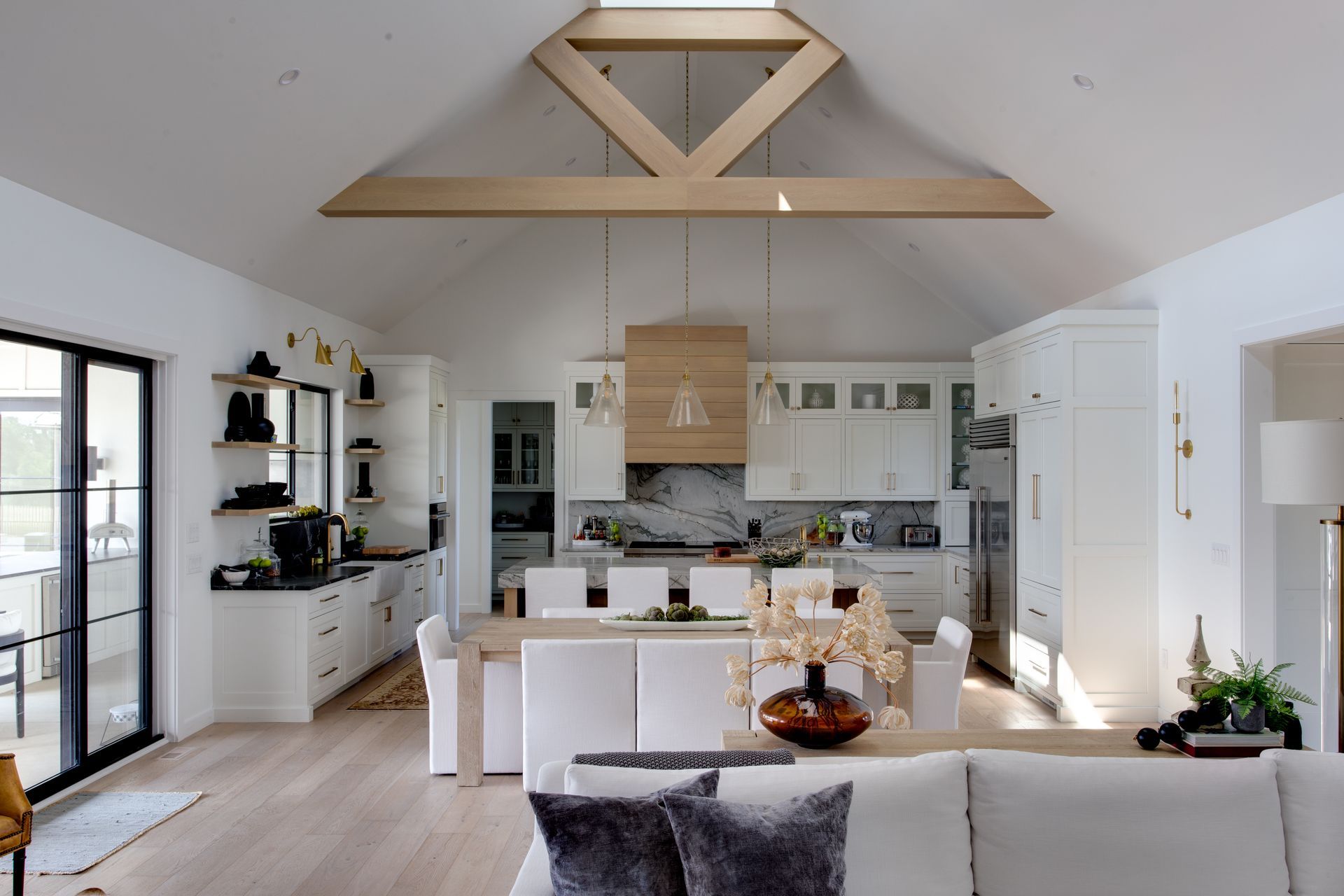A living room with a couch and a kitchen with a skylight.