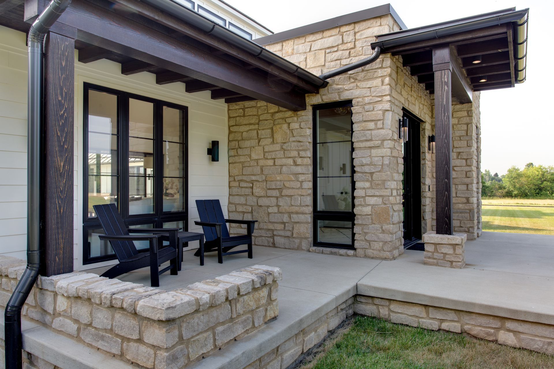 A stone house with a patio and chairs in front of it.