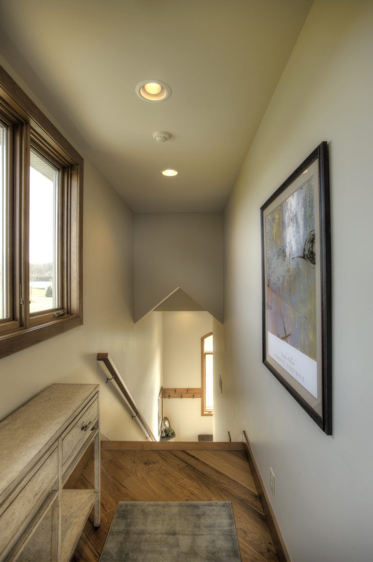 A hallway with stairs and a picture on the wall.