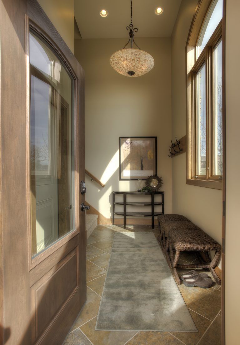 A hallway in a house with a chandelier hanging from the ceiling.