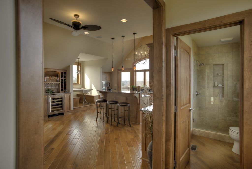 A view of a kitchen and bathroom from a hallway.