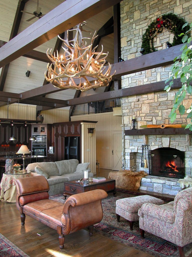 A living room with a fireplace and a chandelier hanging from the ceiling.