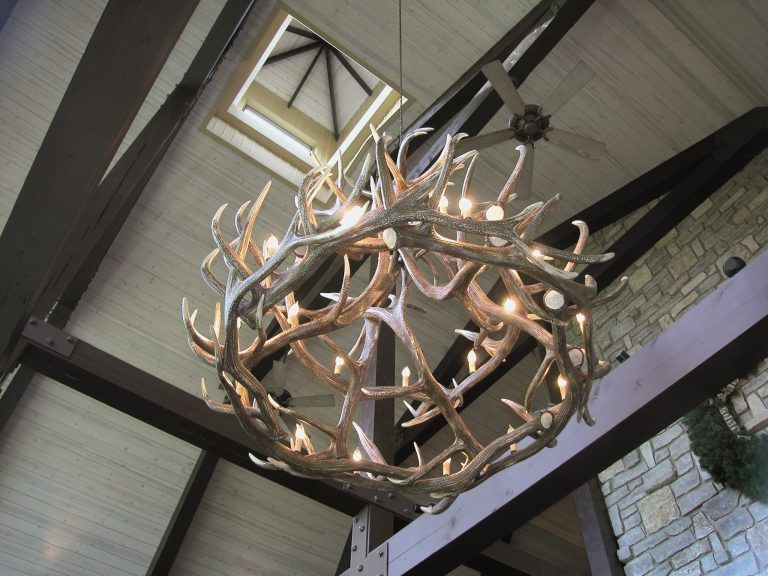 A chandelier made of antlers is hanging from the ceiling.