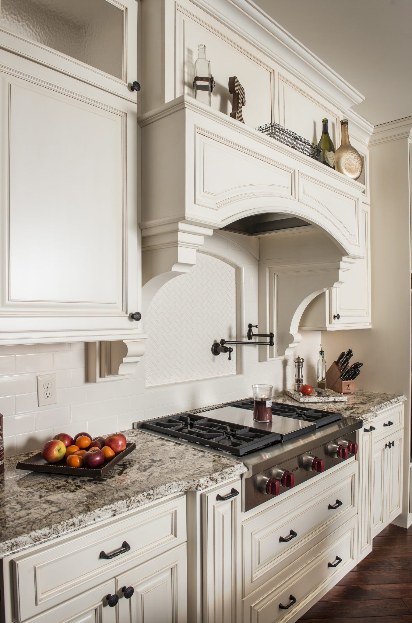 A kitchen with white cabinets and a stove top oven