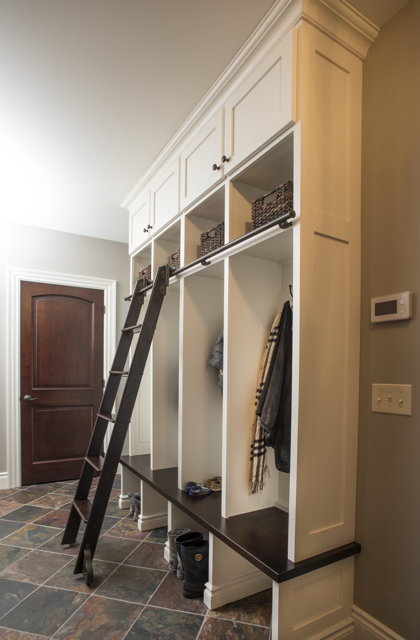 A mud room with a ladder leading up to it.