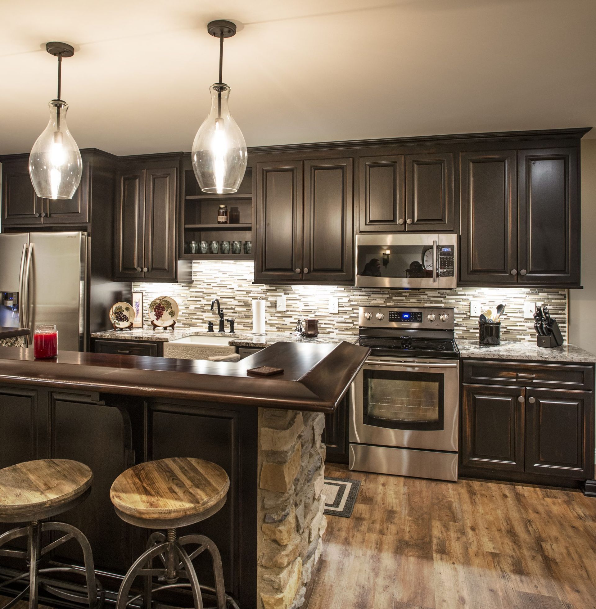 A kitchen with black cabinets and stainless steel appliances.