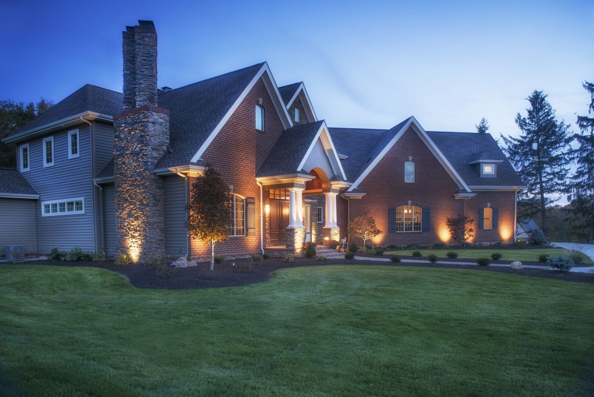 A large brick house is lit up at night.