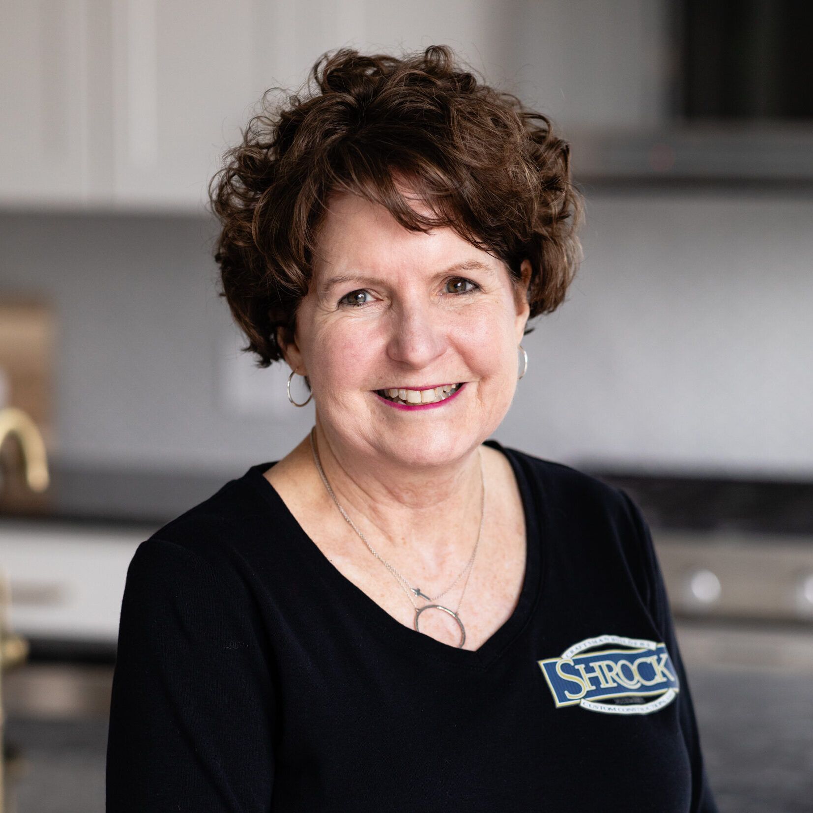 A woman wearing a black shirt with the word Shrock on it.