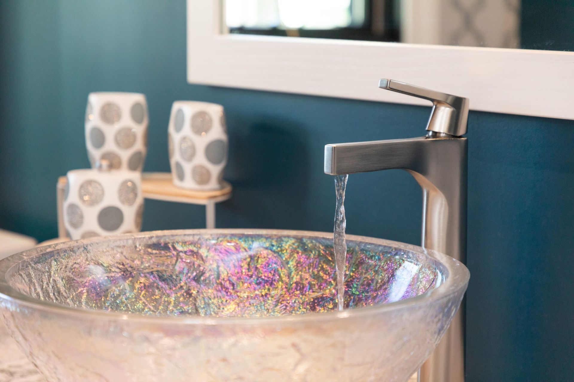 A bathroom sink with a faucet and a mirror.