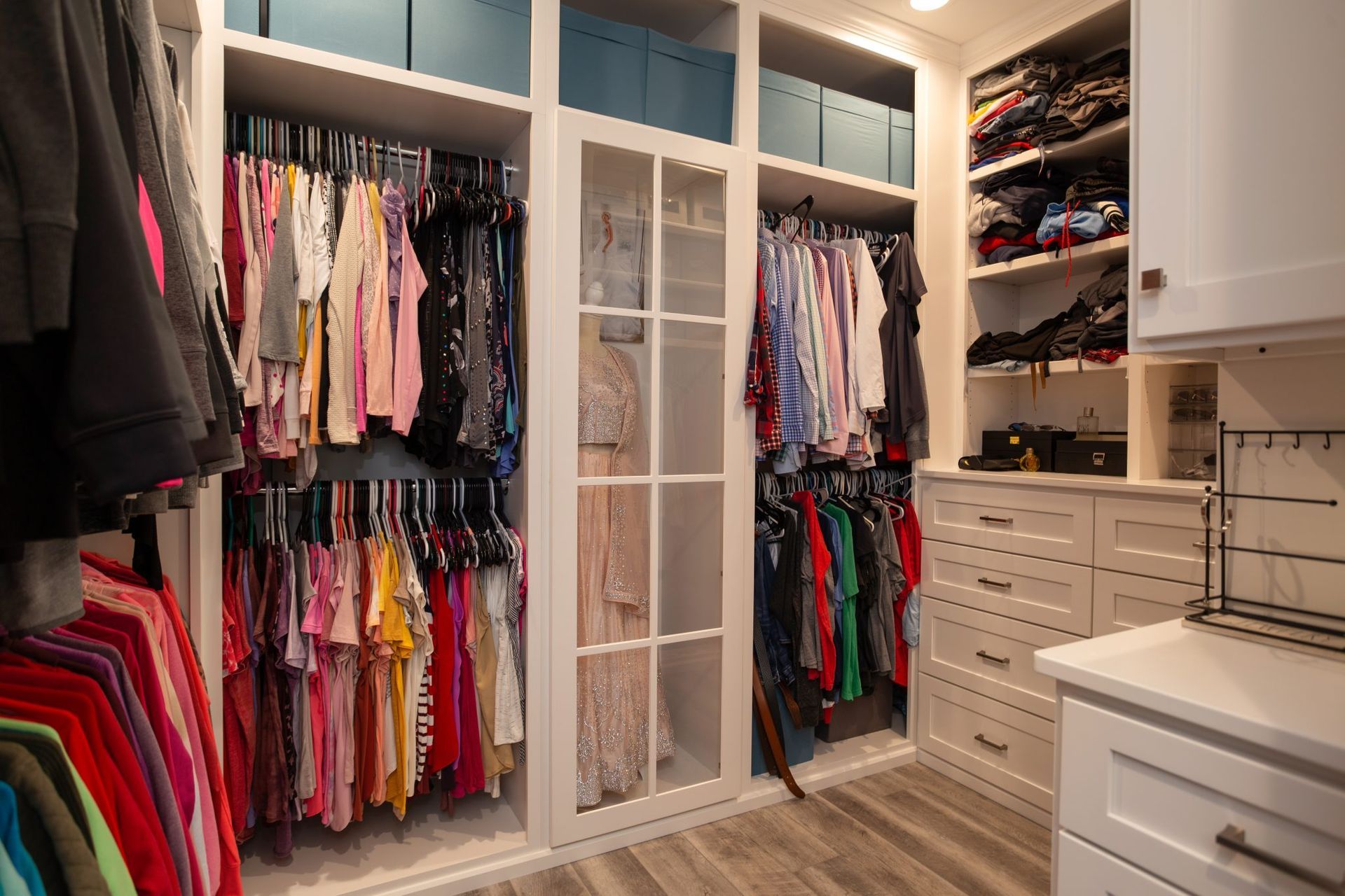 A walk in closet filled with lots of clothes and shoes.