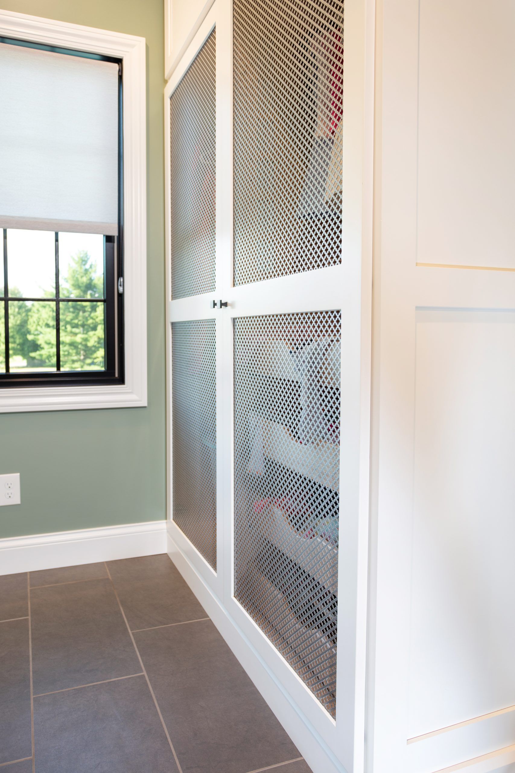 A room with a window and a closet with a mesh door