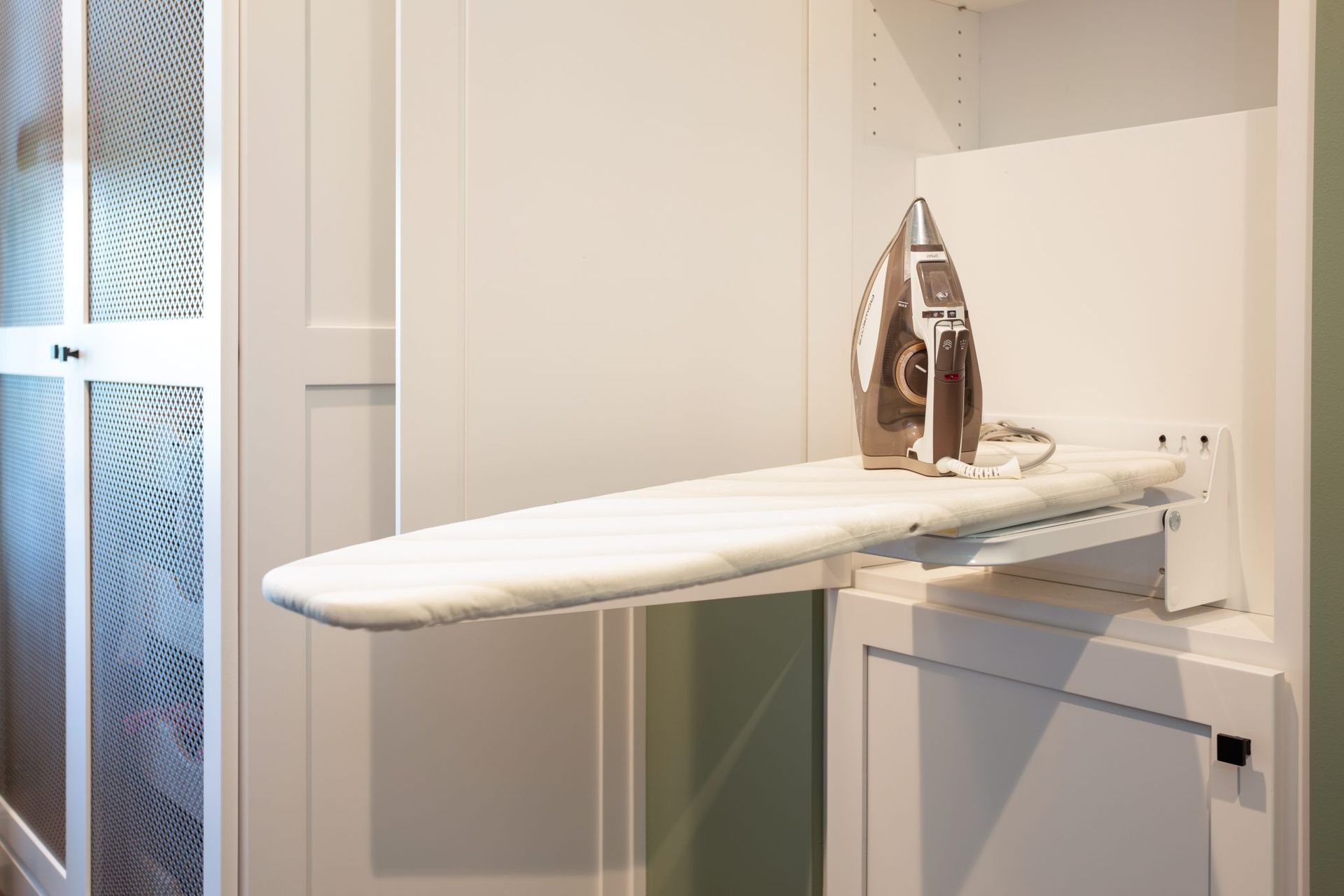 A white ironing board with an iron on it.