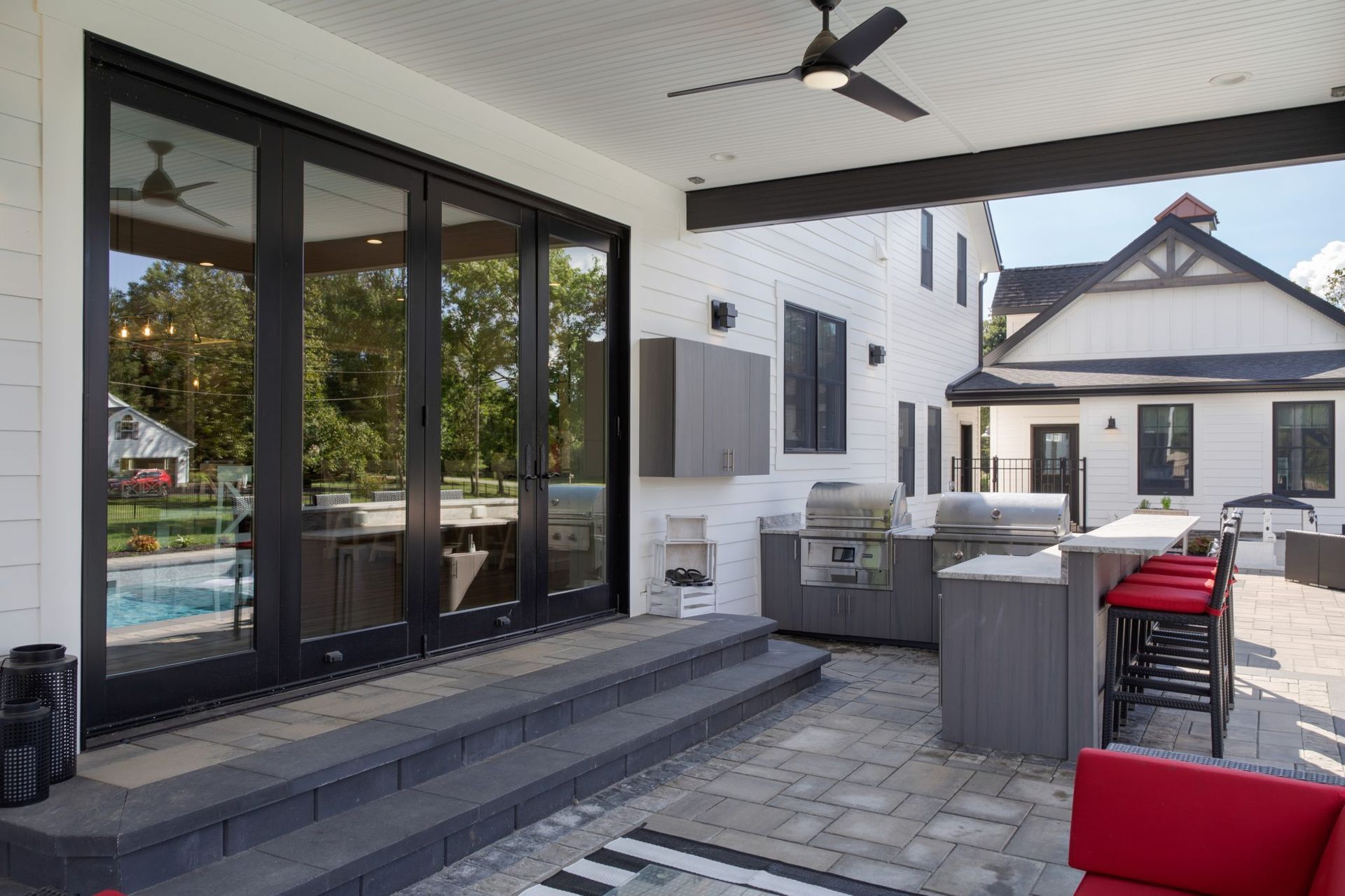 A large white house with a patio area and a ceiling fan