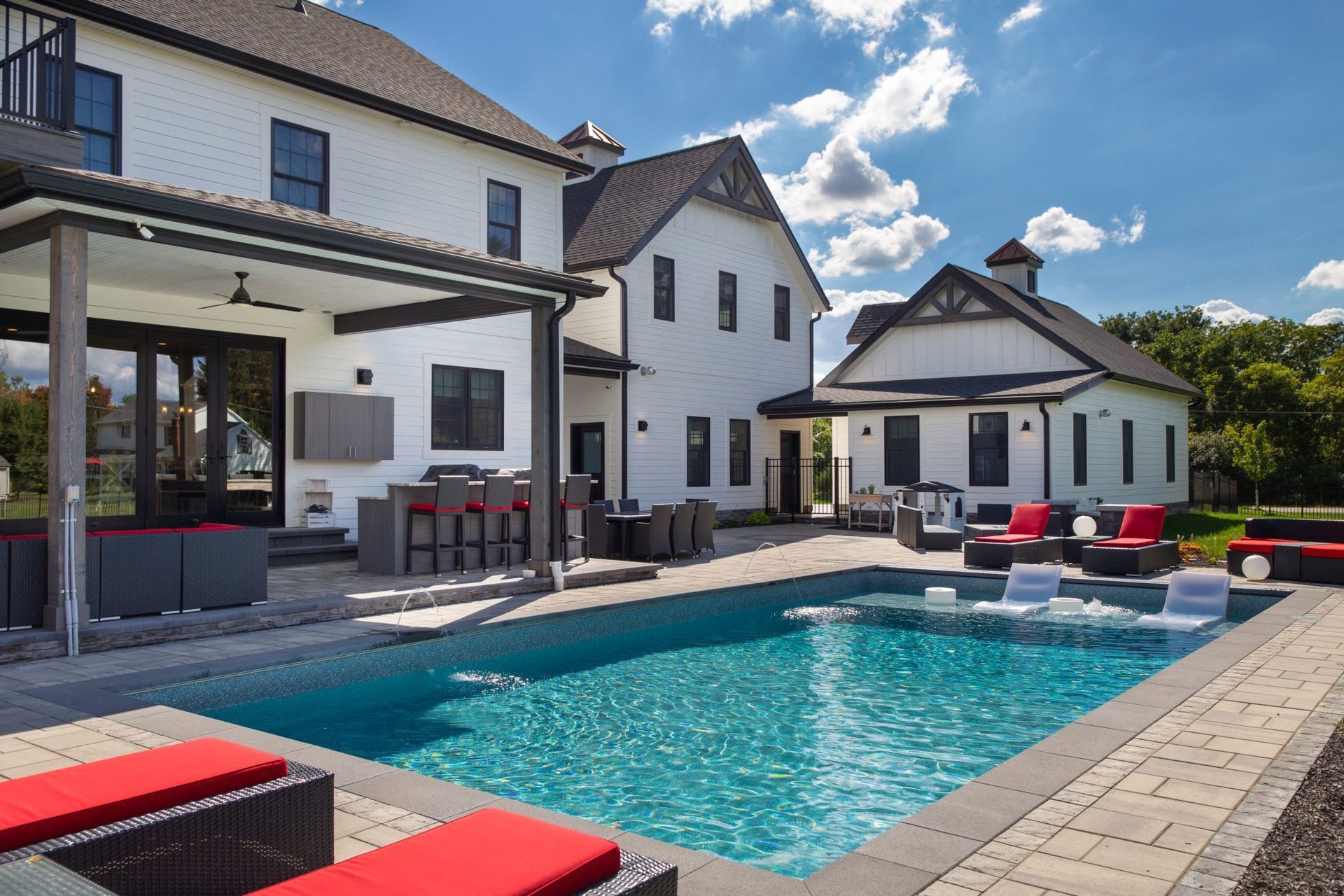 A large white house with a large swimming pool in front of it
