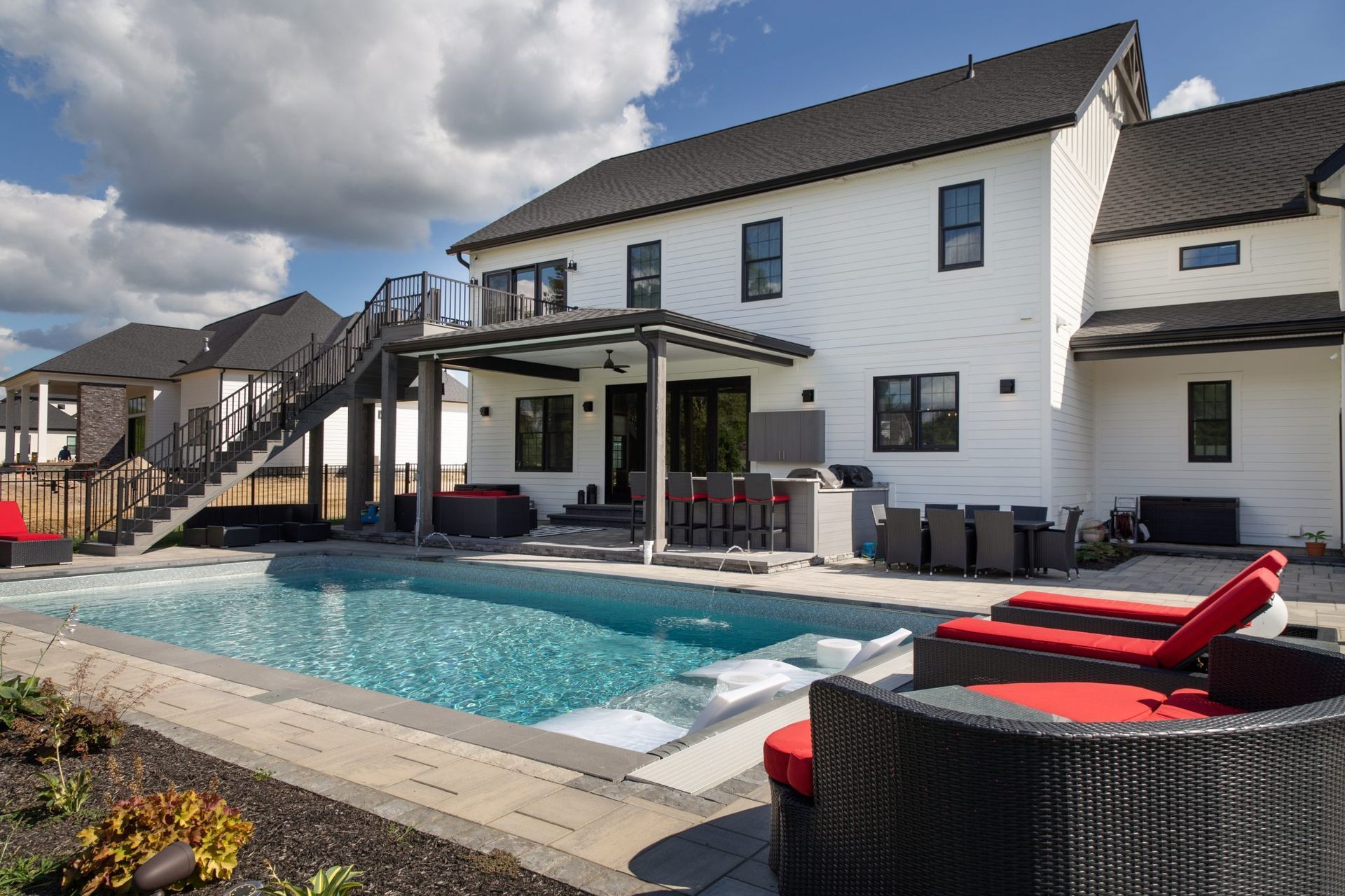 A large white house with a large swimming pool in front of it.