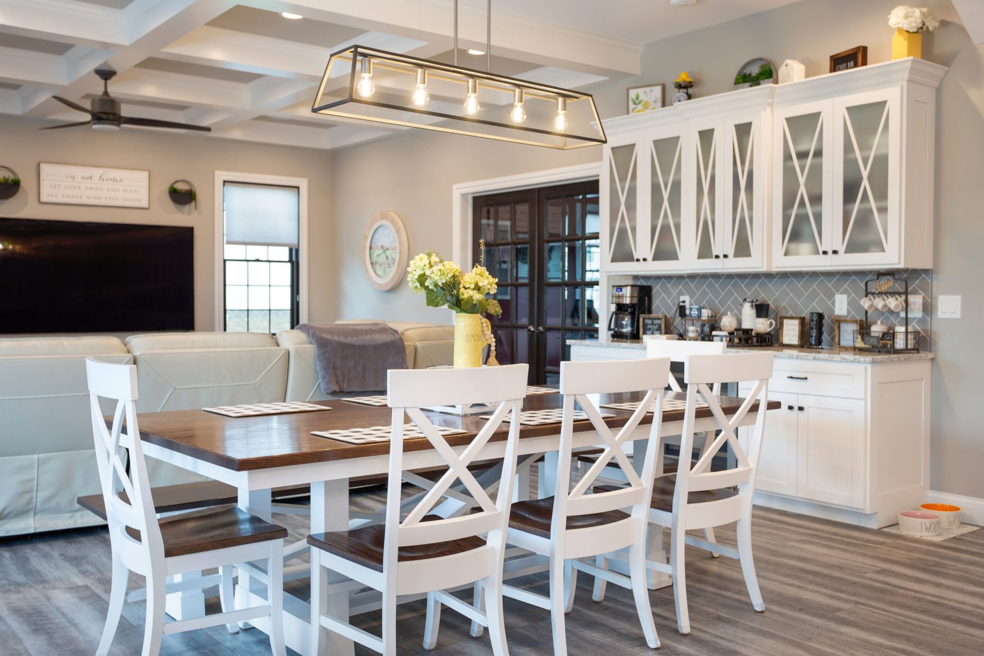 A dining room with a table and chairs and a kitchen.