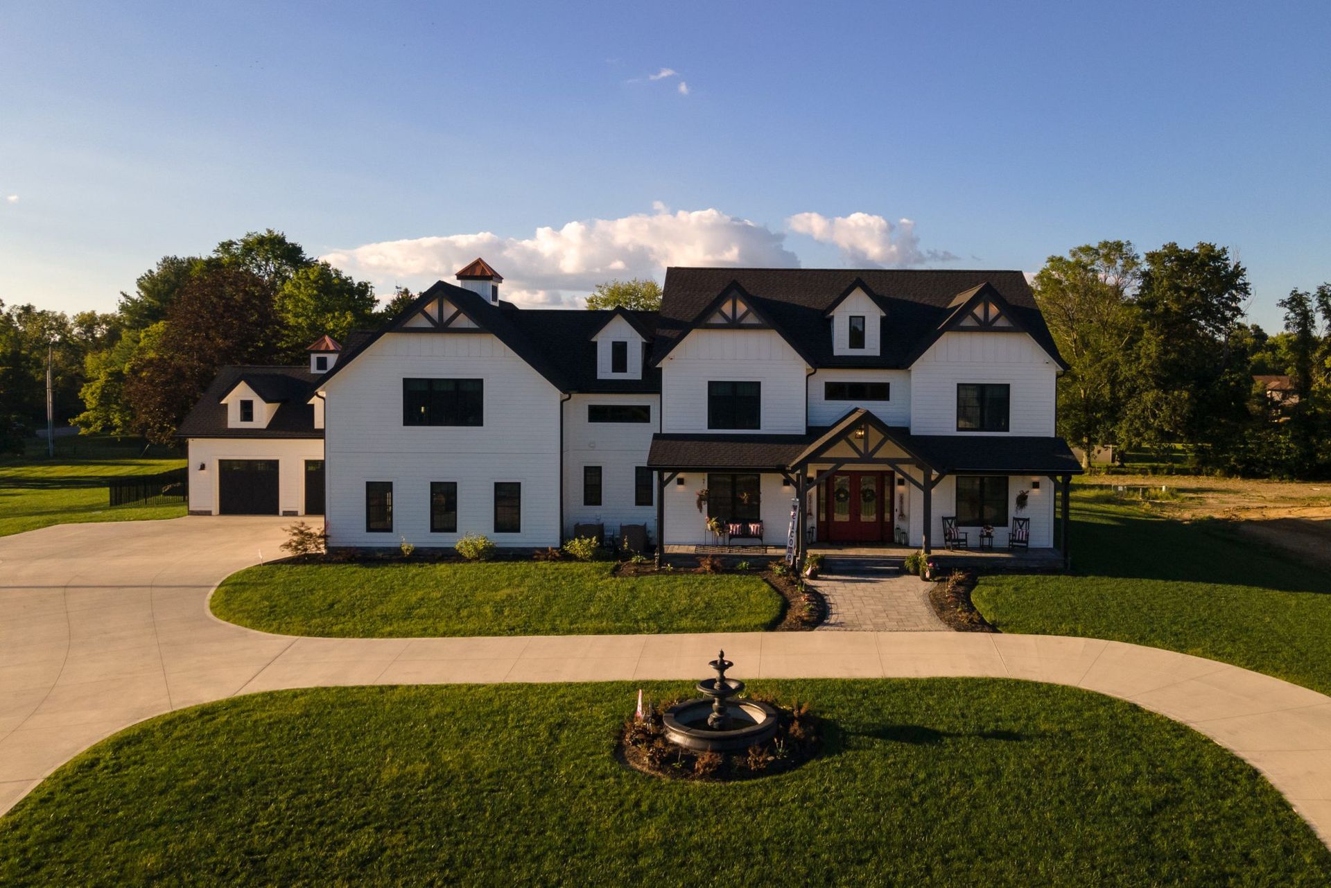 A large white house with a fountain in front of it