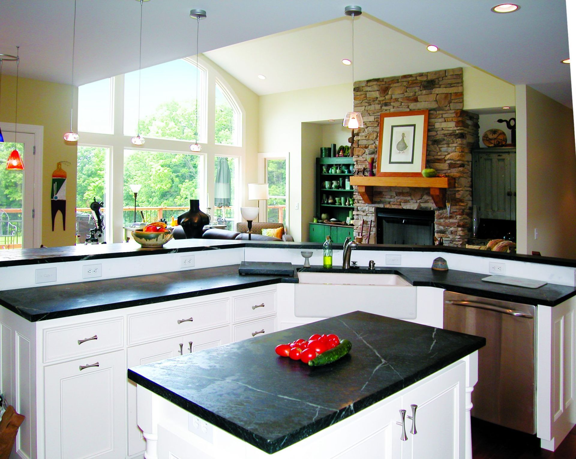 A kitchen with black counter tops and white cabinets.