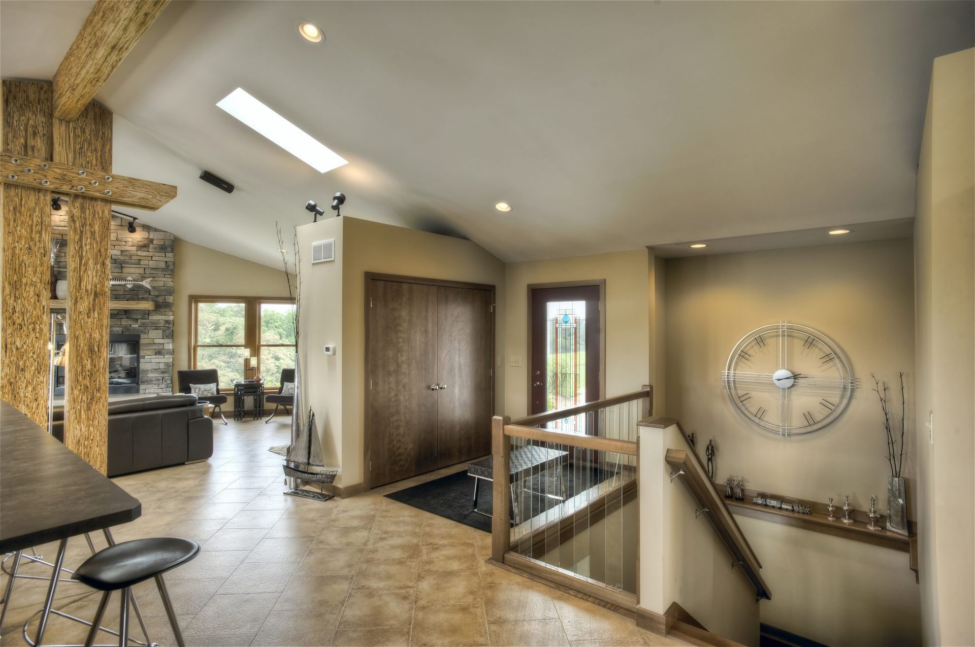 A living room with a clock on the wall and stairs