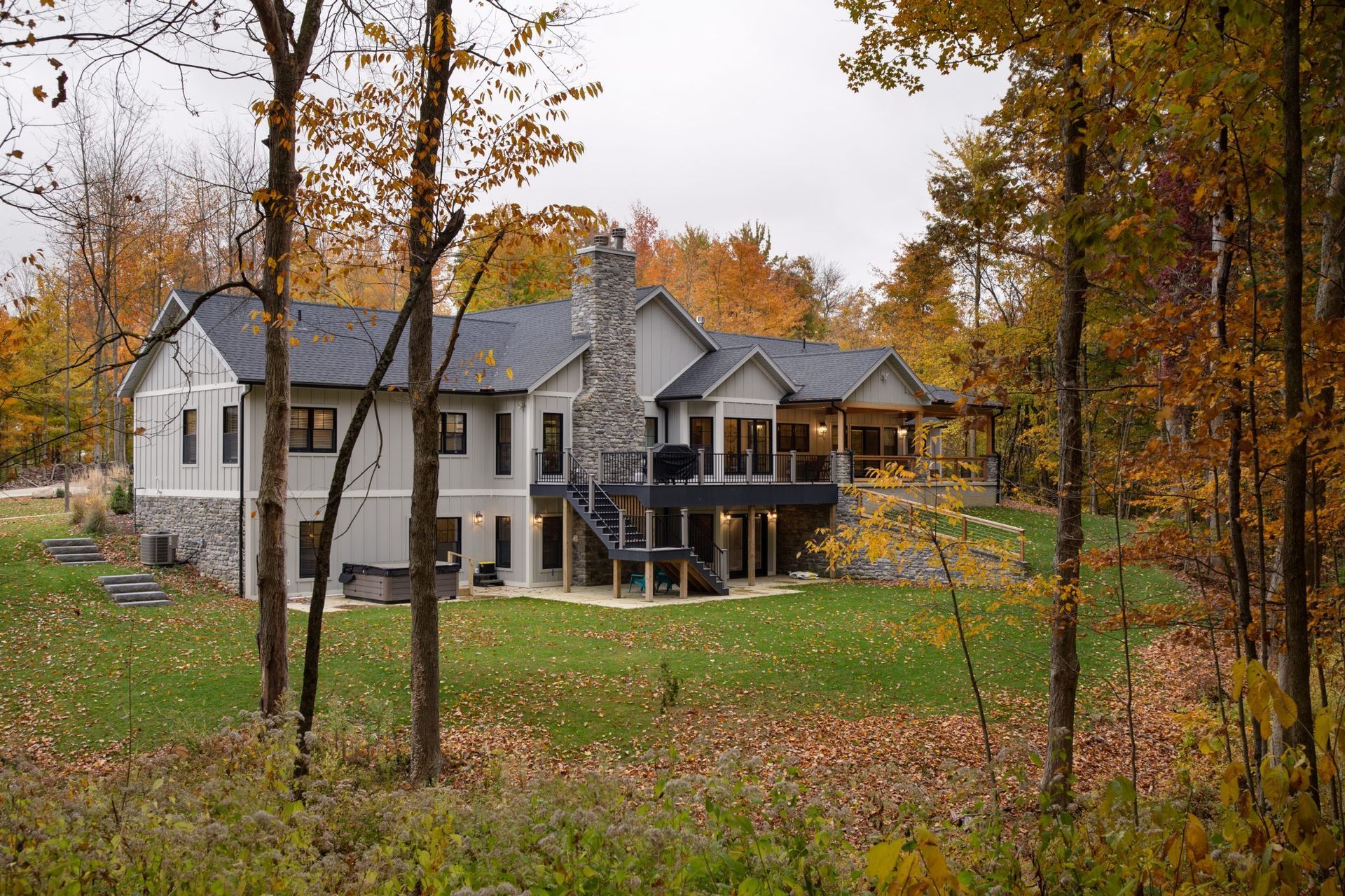 A large house is surrounded by trees in the middle of a forest.