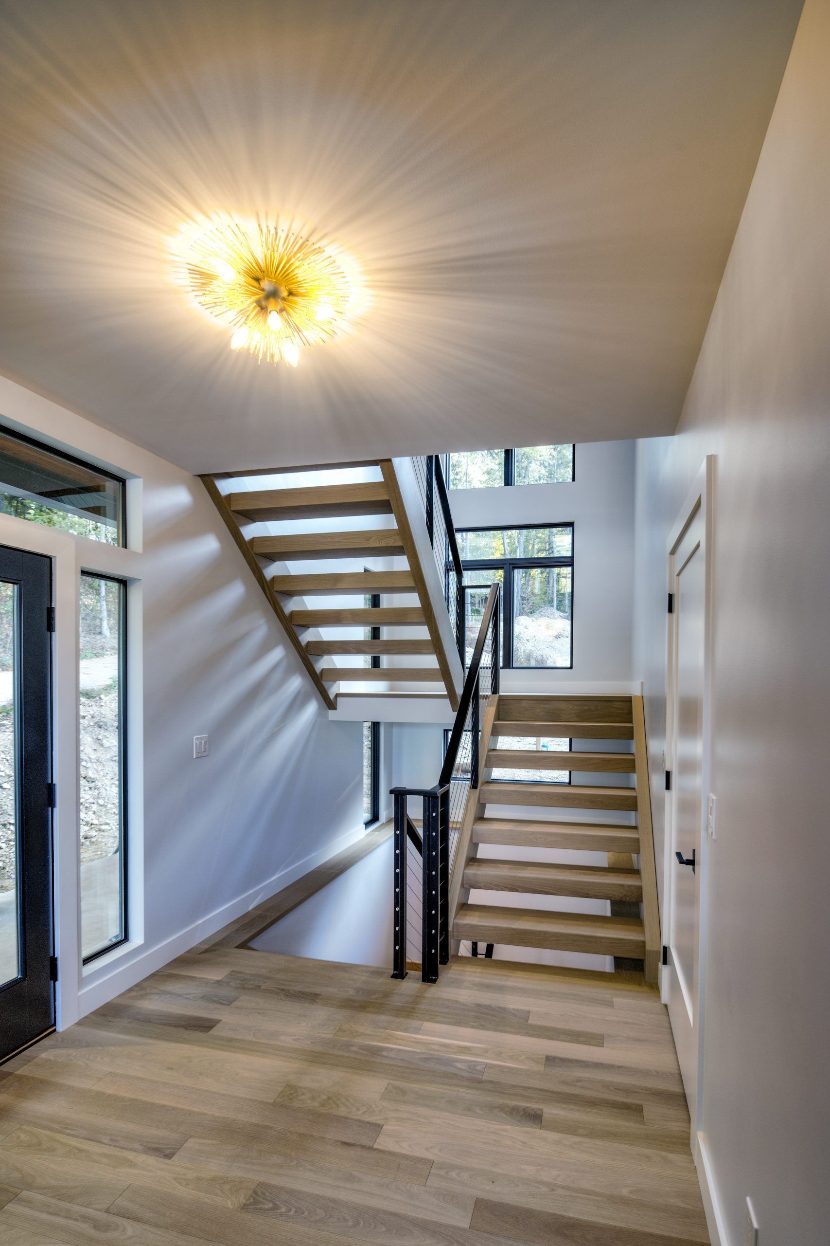 A hallway with stairs leading up to the second floor of a house.
