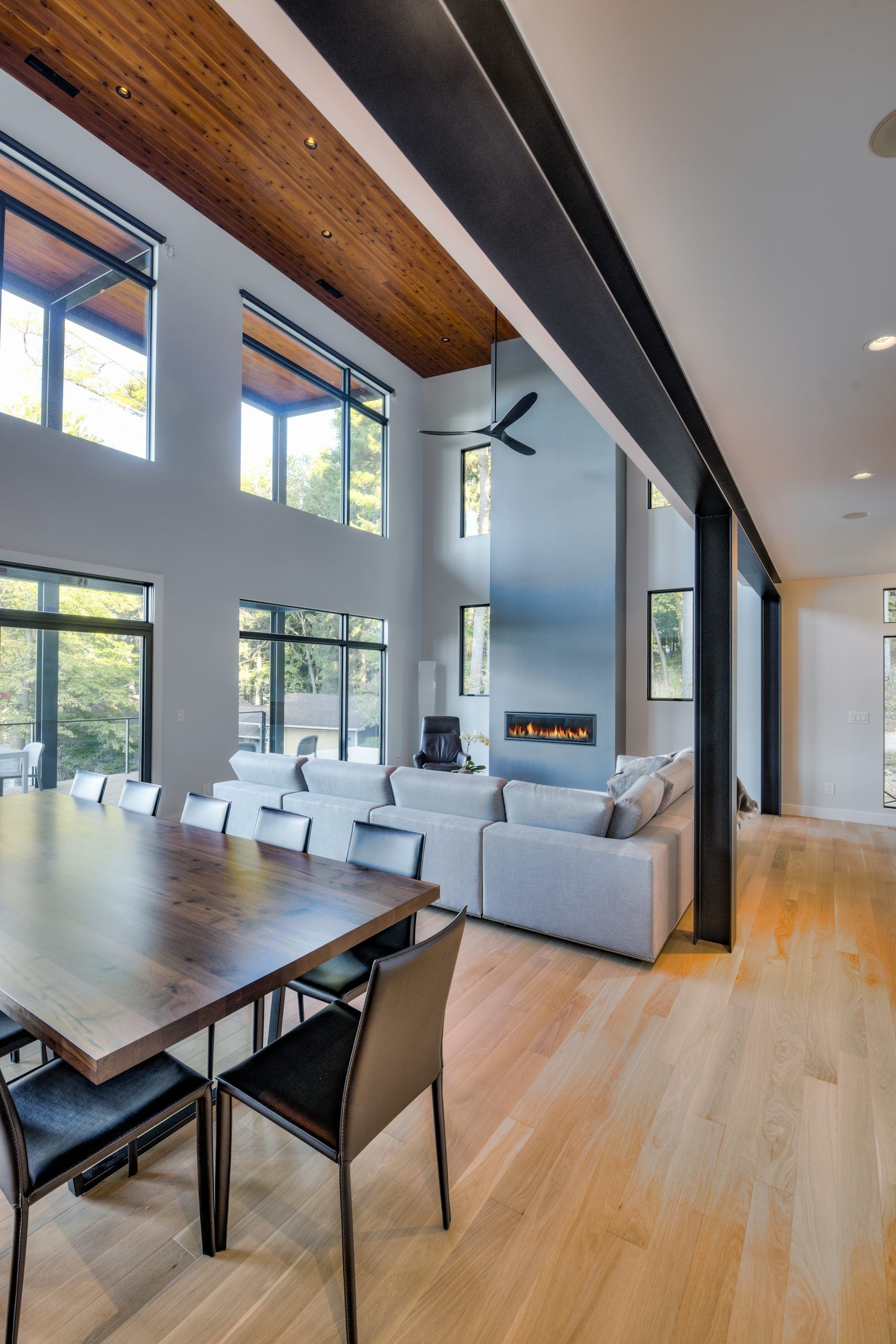 A large open living room with a table and chairs and a fireplace.