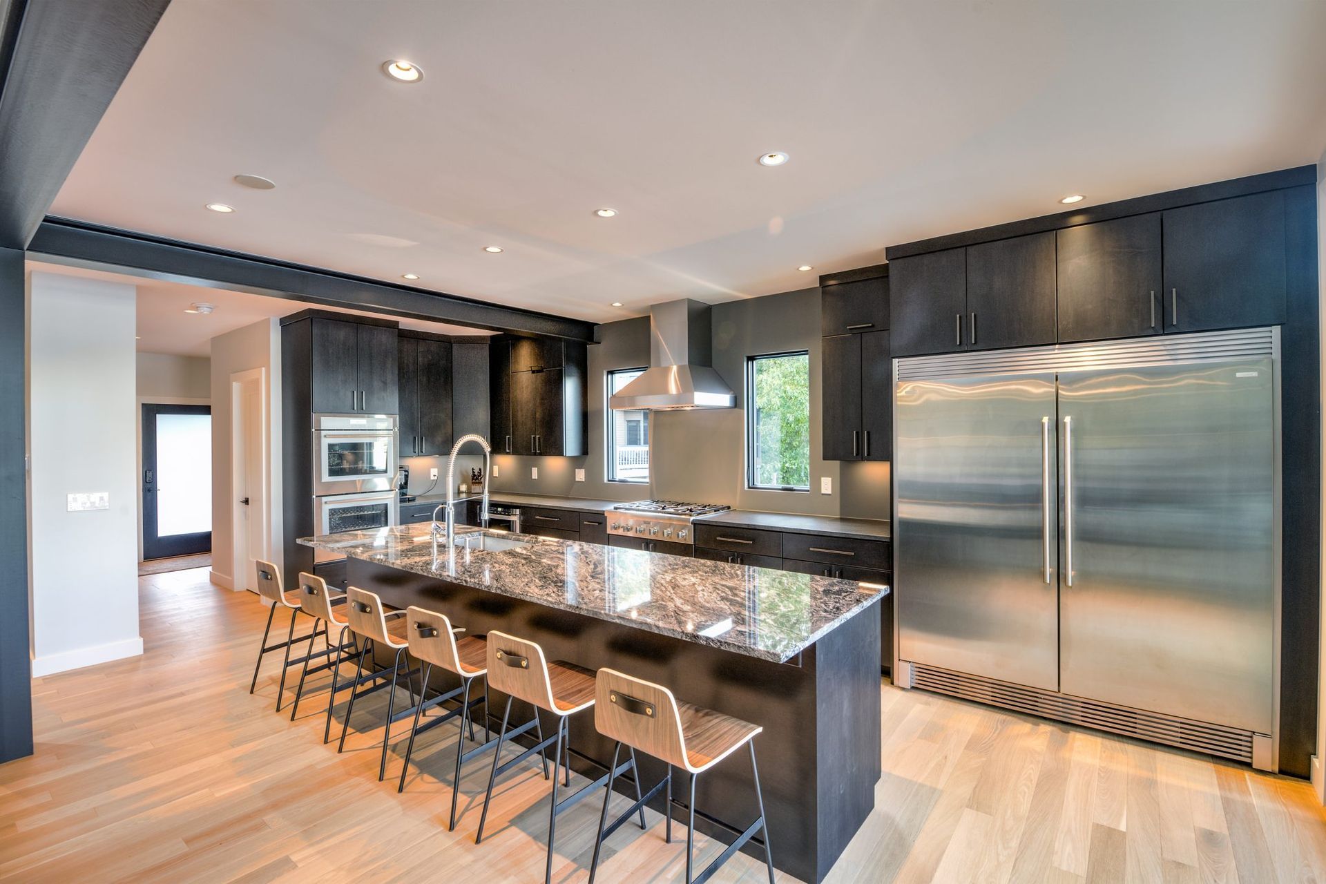 A large kitchen with stainless steel appliances and granite counter tops.