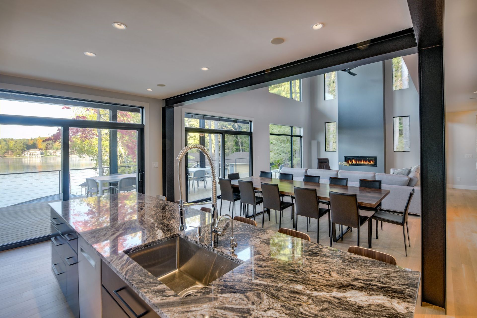A kitchen with a sink , dining table and chairs.