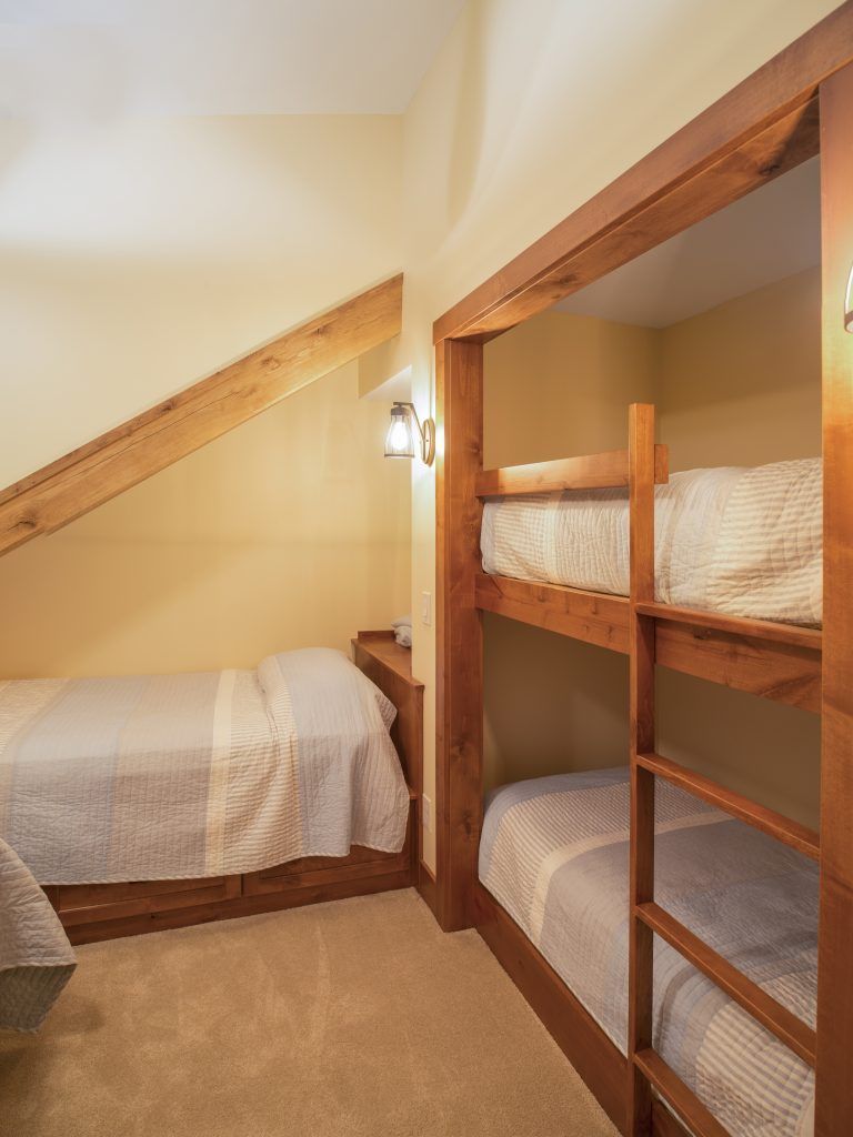 A bedroom with two bunk beds and two single beds.