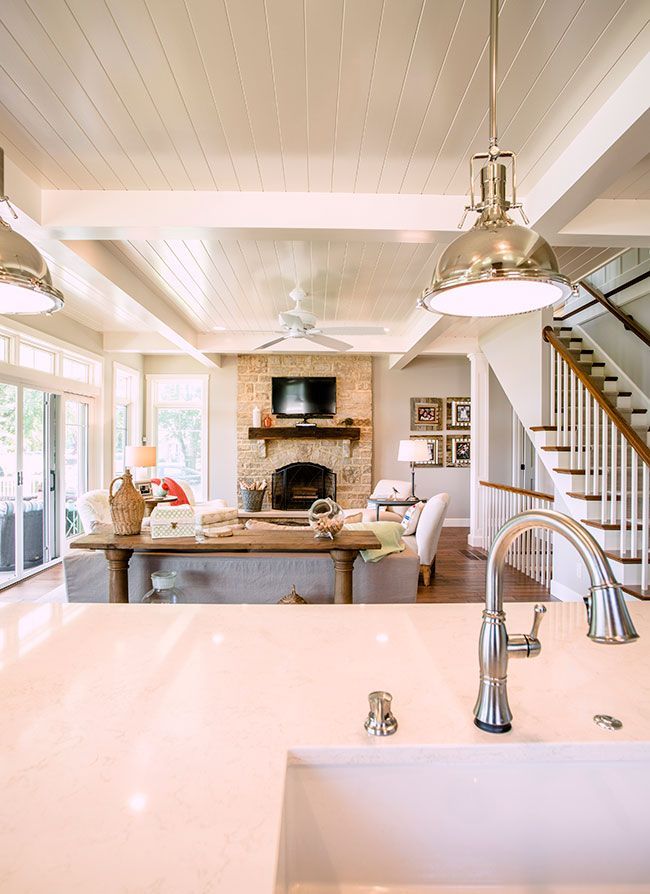 A kitchen with a sink and stairs leading to a living room.