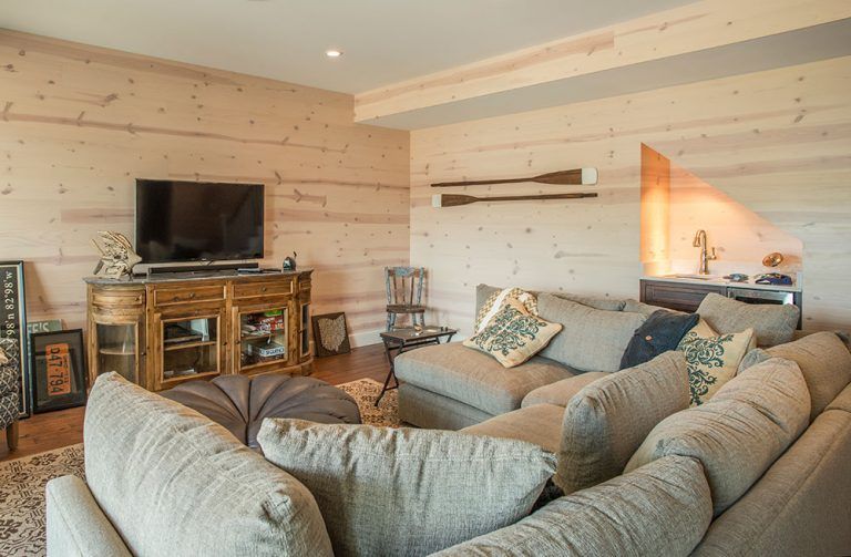 A living room with a large sectional couch and a flat screen tv.