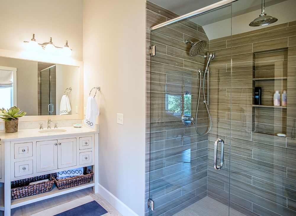 A bathroom with a walk in shower and a sink.